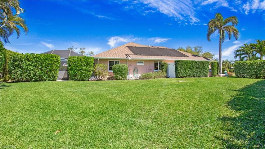 Side view of property featuring a yard and pool solar heat system