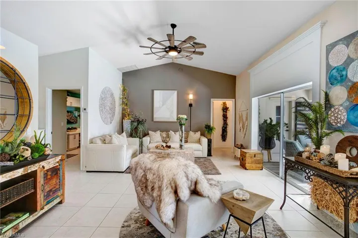 Tiled living room featuring vaulted ceiling and ceiling fan
