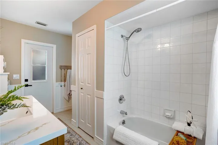 Bathroom with tile floors, vanity, and shower / tub combo