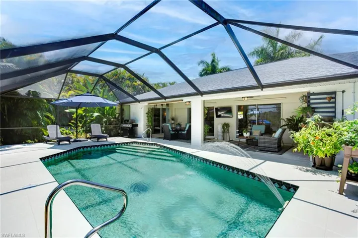 View of swimming pool featuring glass enclosure, a patio area, and an outdoor hangout area