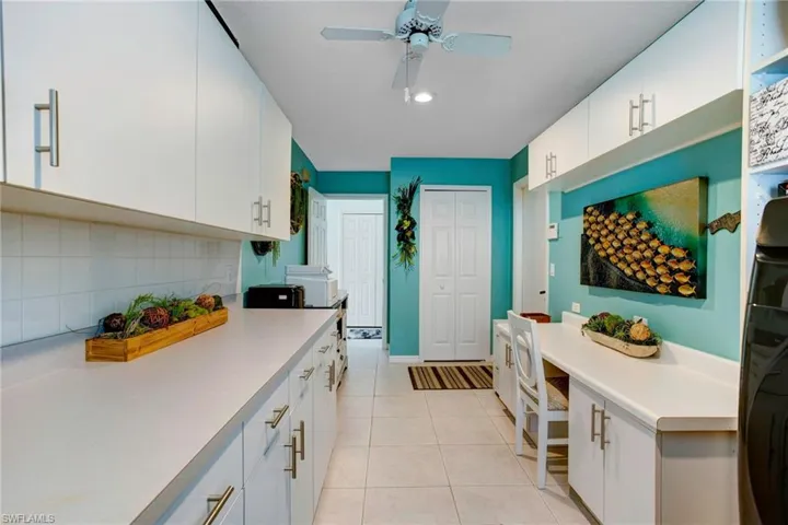 Kitchen featuring white cabinets, ceiling fan, tasteful backsplash, and light tile floors