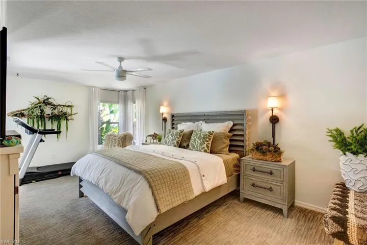 Carpeted bedroom featuring ceiling fan