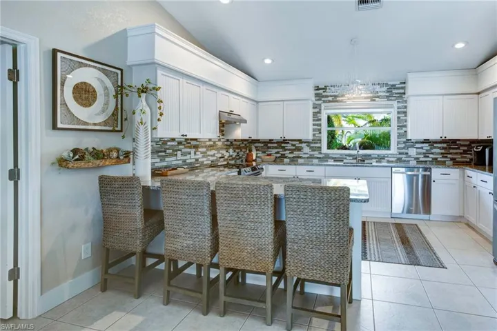 Kitchen featuring appliances with stainless steel finishes, tasteful backsplash, and light tile floors