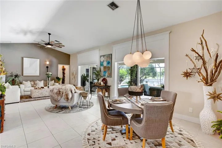 Tiled dining area with lofted ceiling and ceiling fan