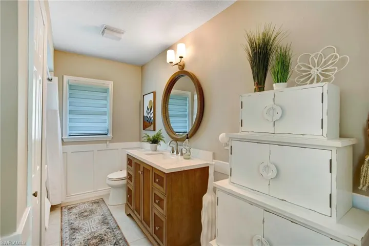Bathroom featuring a textured ceiling, vanity, toilet, and tile floors