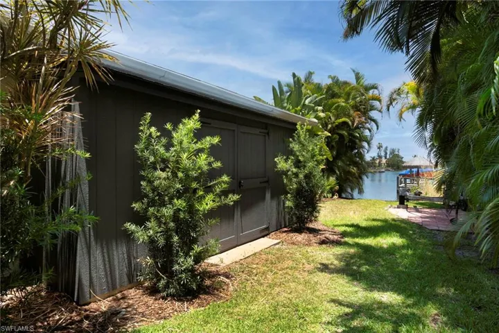 View of yard with an outdoor structure and a water view