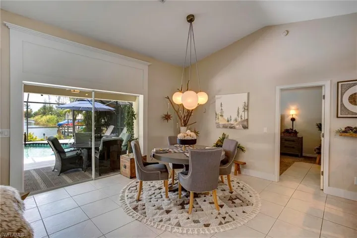 Tiled dining room featuring high vaulted ceiling