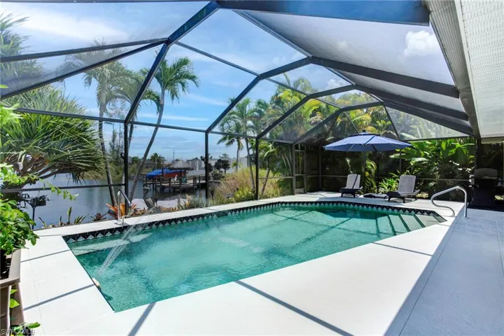 View of swimming pool featuring a patio and glass enclosure