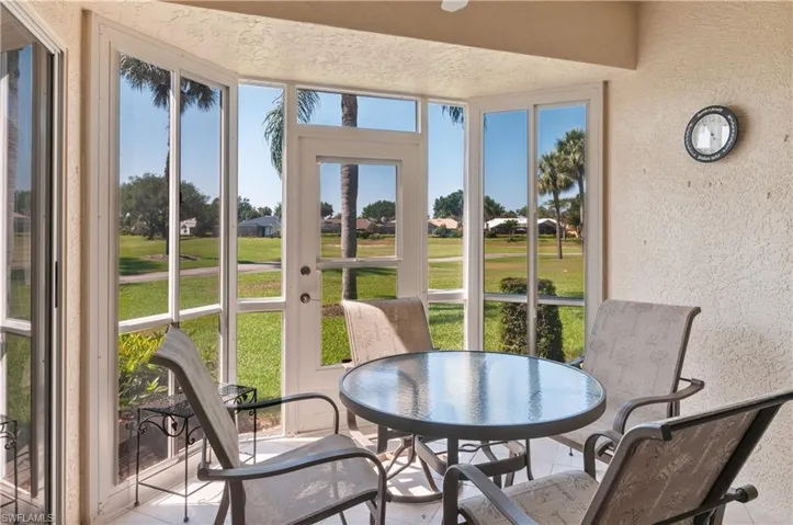 Closed in lanai adding more living under air, featuring tile flooring and golf course views