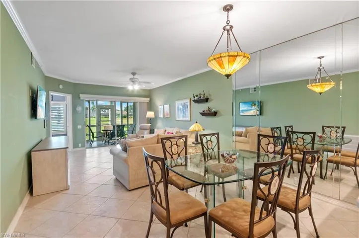 Dining room featuring a ceiling fan, ornamental molding, and light tile patterned floors