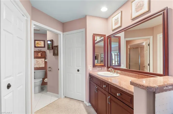Primary bathroom with access to walk in closet to your left,  shower and toilet center and walk in closet to the right.