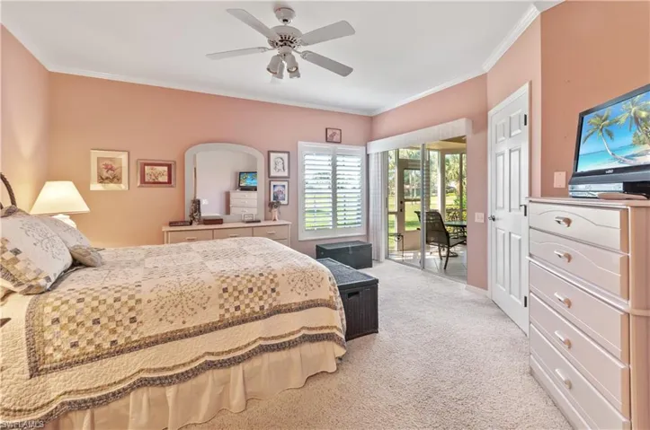 Primary bedroom with entrance to lanai and professionally installed Plantation shutters