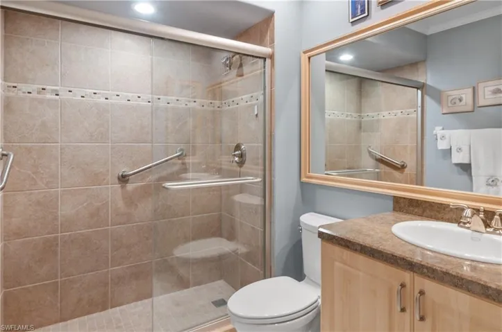 Guest bathroom featuring vanity, recessed lighting, a shower stall, and toilet