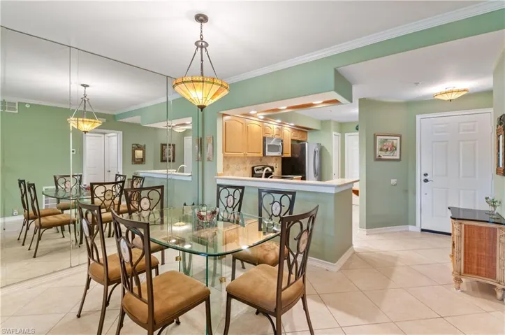 Dining room featuring crown molding, baseboards, and light tile patterned floors