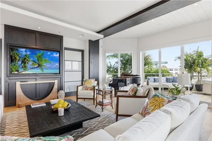 Living area featuring beam ceiling, light wood-style floors, and recessed lighting