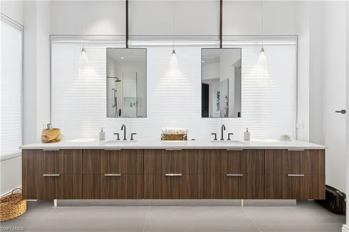 Full bath with double vanity, a shower, and light tile patterned floors