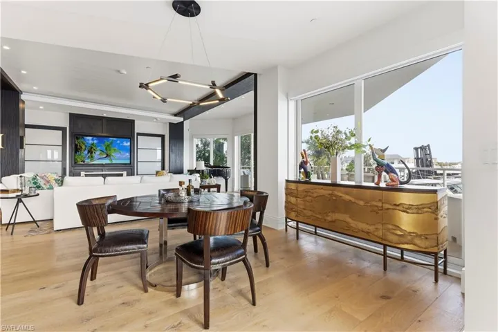 Dining area with light wood finished floors and hanging lights