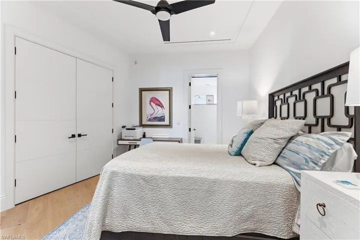 Bedroom with light wood-style floors, ceiling fan, and a closet