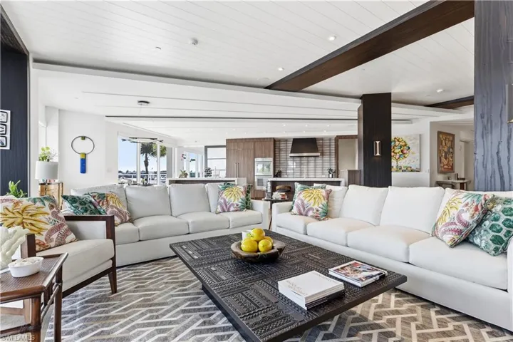 Living area featuring beamed ceiling and recessed lighting
