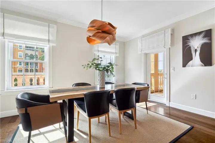 Dining room with wood-type flooring, crown molding, and a wealth of natural light