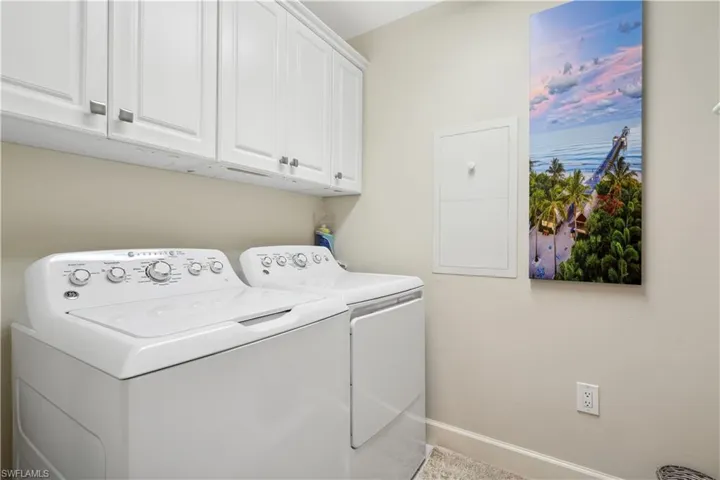 Laundry room featuring cabinets and washing machine and clothes dryer