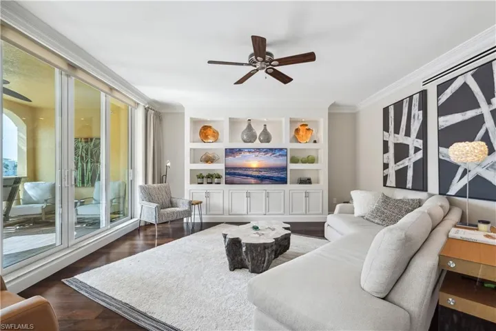 Living room featuring ceiling fan, dark hardwood / wood-style floors, and ornamental molding