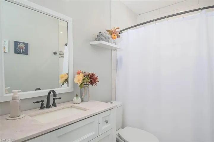 Bathroom featuring vanity, toilet, and a shower with shower curtain