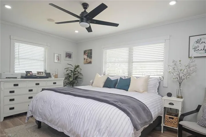 Bedroom with crown molding, dark hardwood / wood-style floors, and ceiling fan