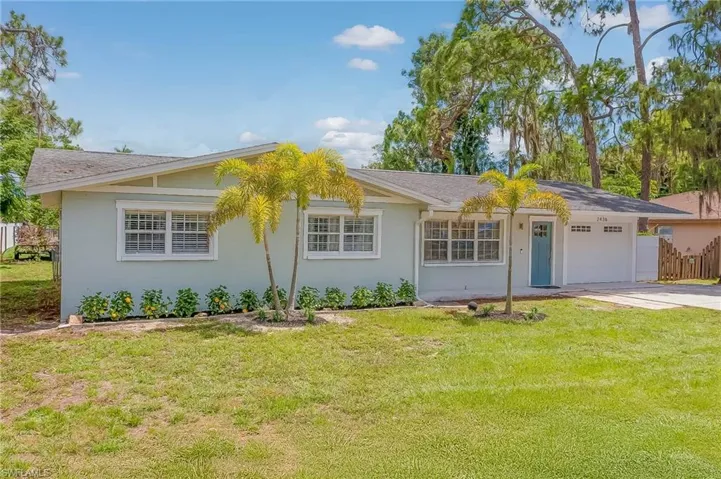 Ranch-style home featuring a front yard and a garage