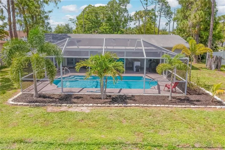 View of swimming pool featuring a lawn, a patio, and glass enclosure