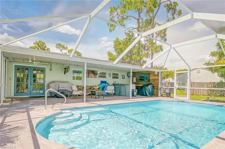 View of pool with a patio, a storage shed, and a lanai