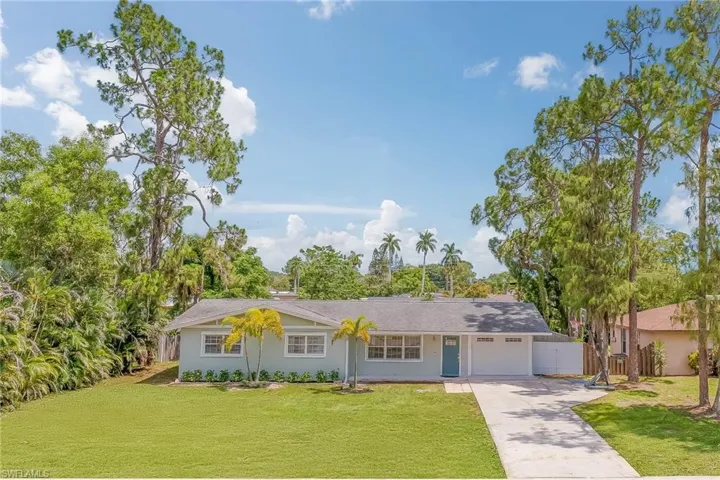 Ranch-style home featuring a garage and a front lawn