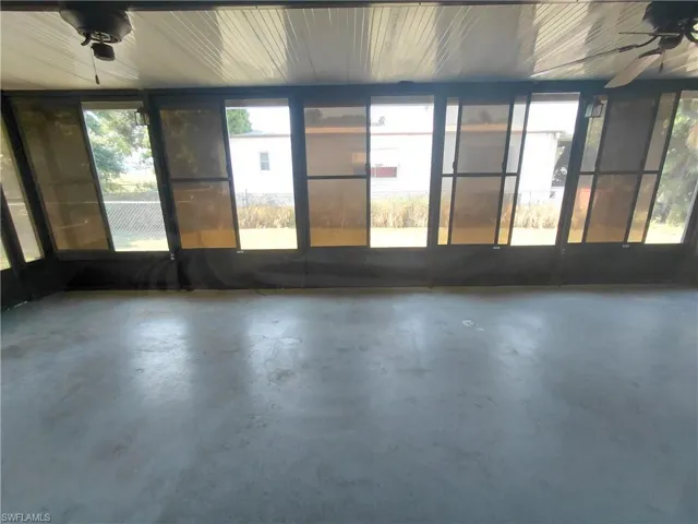 Unfurnished sunroom with ceiling fan