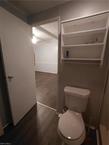 Bathroom with dark wood finished floors and toilet