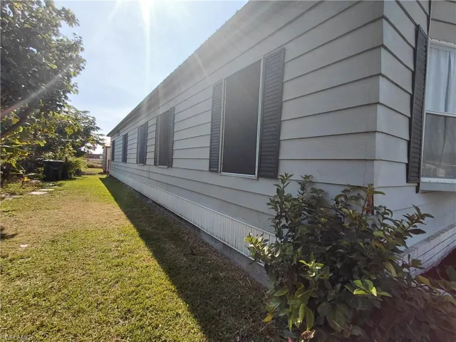 View of side of home featuring a lawn