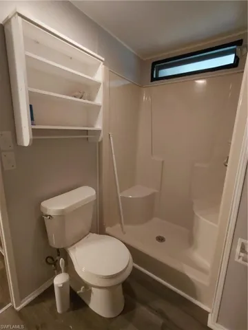 Bathroom featuring a stall shower and dark wood-style floors