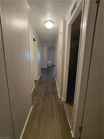 Hallway featuring dark wood-style flooring and a textured ceiling