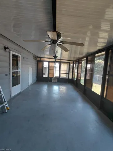 Unfurnished sunroom featuring a ceiling fan