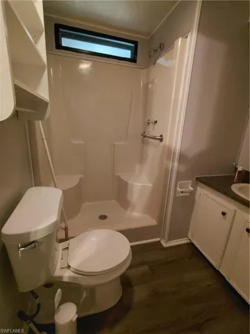 Bathroom featuring vanity, a shower stall, and dark wood finished floors