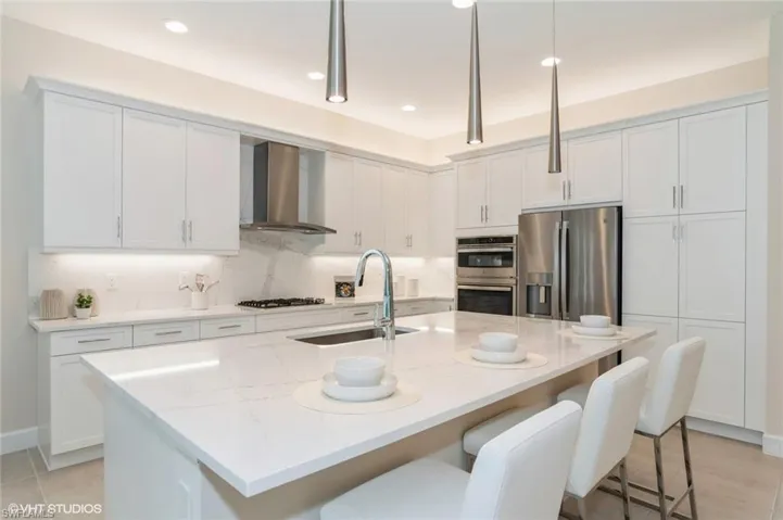 White and bright, with plenty of storage, bar seating, and designer lighting