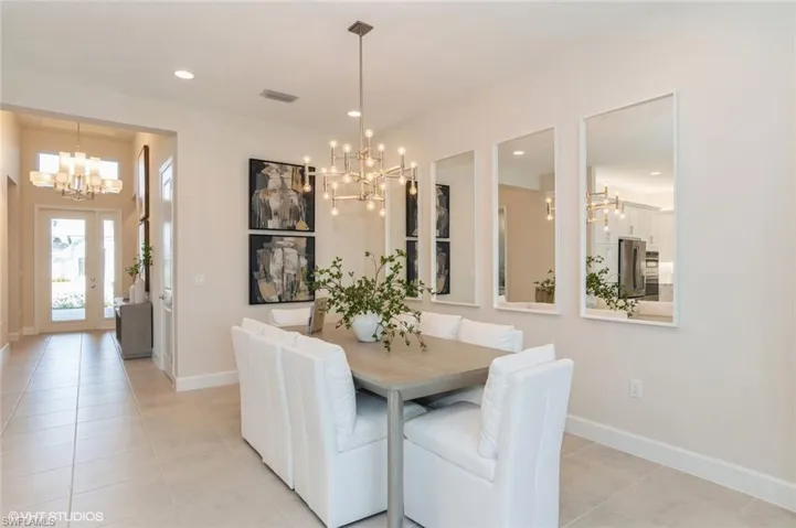 Dining area with light tile patterned flooring and a notable chandelier