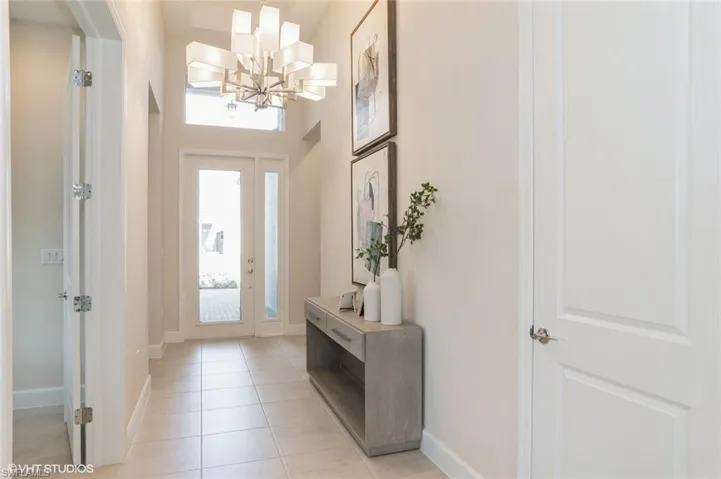 Tiled foyer with a high ceiling and a chandelier