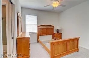 Bedroom with a ceiling fan and light colored carpet