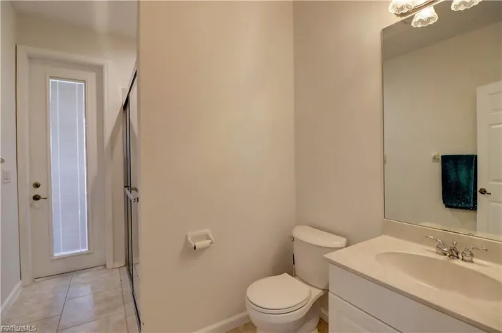 Full bathroom with vanity, a stall shower, and light tile patterned flooring