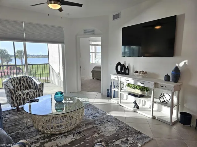 Living room featuring light tile patterned floors, ceiling fan, and visible vents