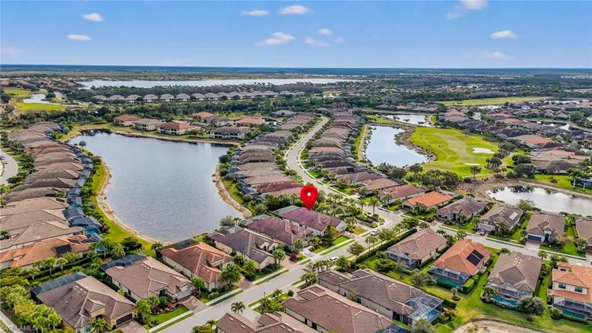 Aerial overview of property's location with nearby suburban area, a large body of water, and a local golf course