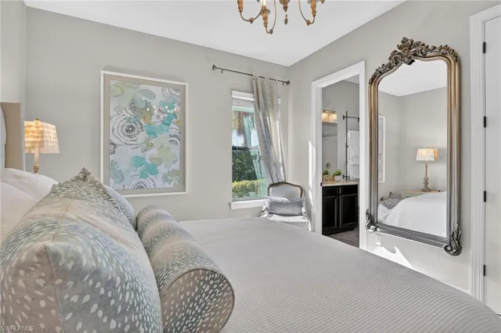Bedroom featuring hanging lights and ensuite bath