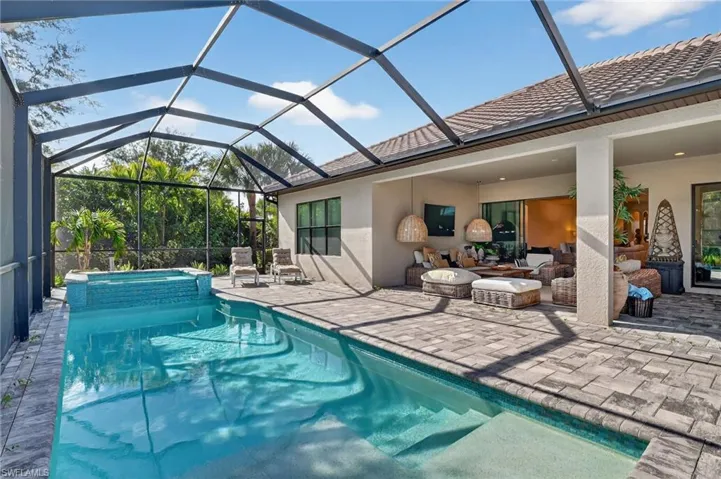 Integrated pool / spa with a patio, glass enclosure, a sunroom, and an outdoor living space
