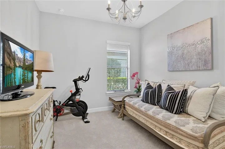 Bedroom with hanging lights and light carpet