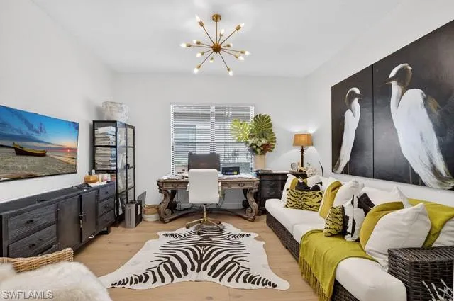 Home office featuring light wood-style flooring and suspended lighting